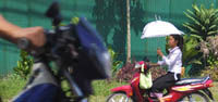 Motorcyclists with parasols -- a surprisingly common sight